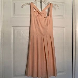 Bow-on-back cocktail dress with flattering pleats